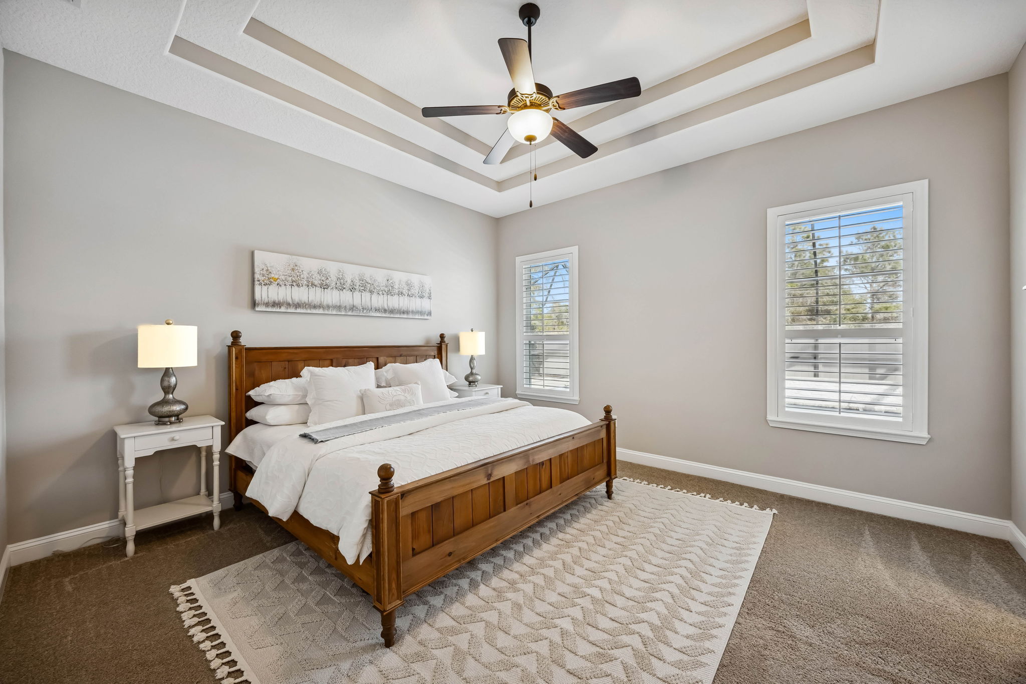 Elevated by a tray ceiling with crown molding and filled with natural light ...