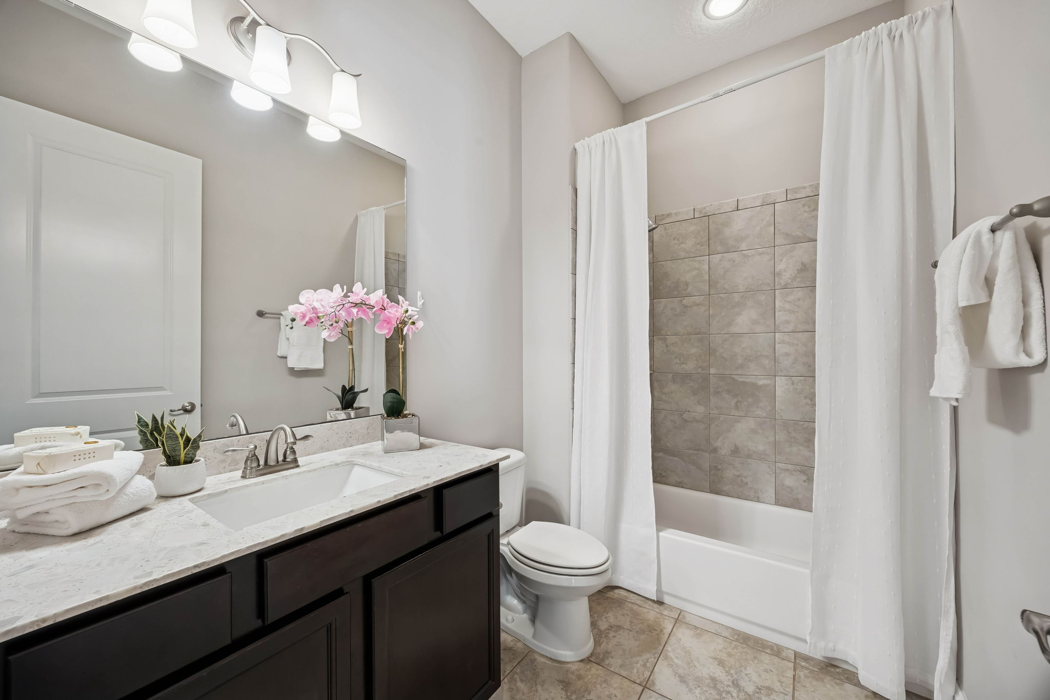 ... while close by, a guest bath features contemporary fixtures and a shower/tub combo
