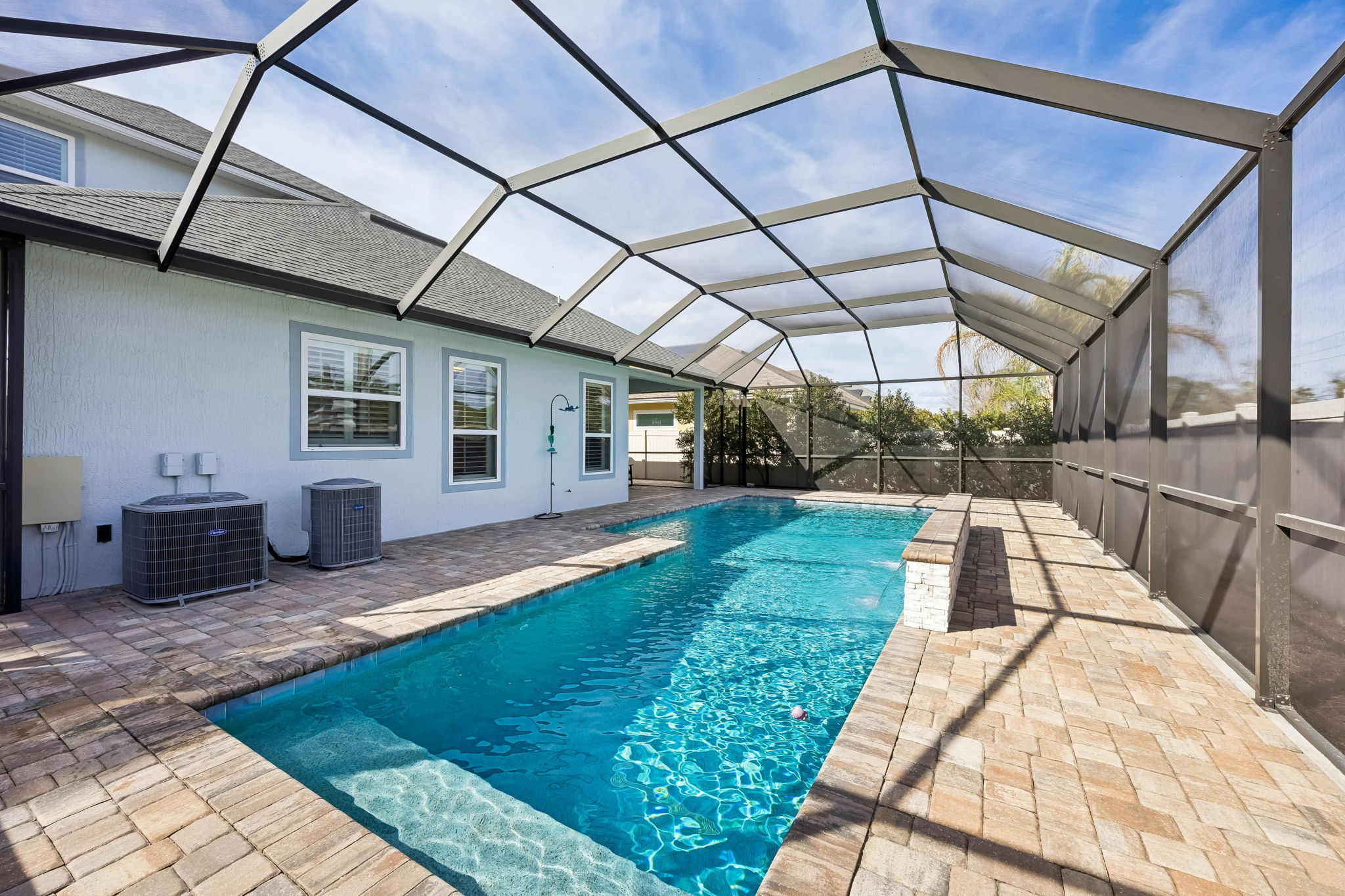 The 15,000-gallon pool includes a sun shelf for lounging and a depth range from 3 to 6.5 feet