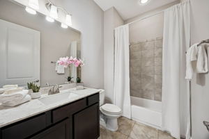 ... while close by, a guest bath features contemporary fixtures and a shower/tub combo