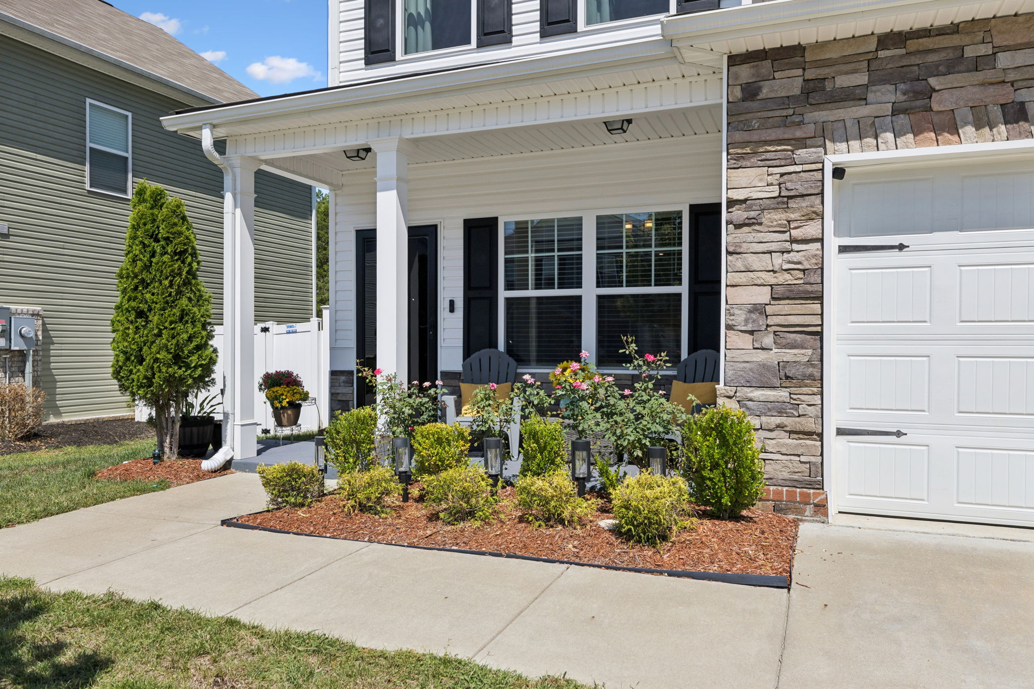 Covered front porch with beautiful landscaping.