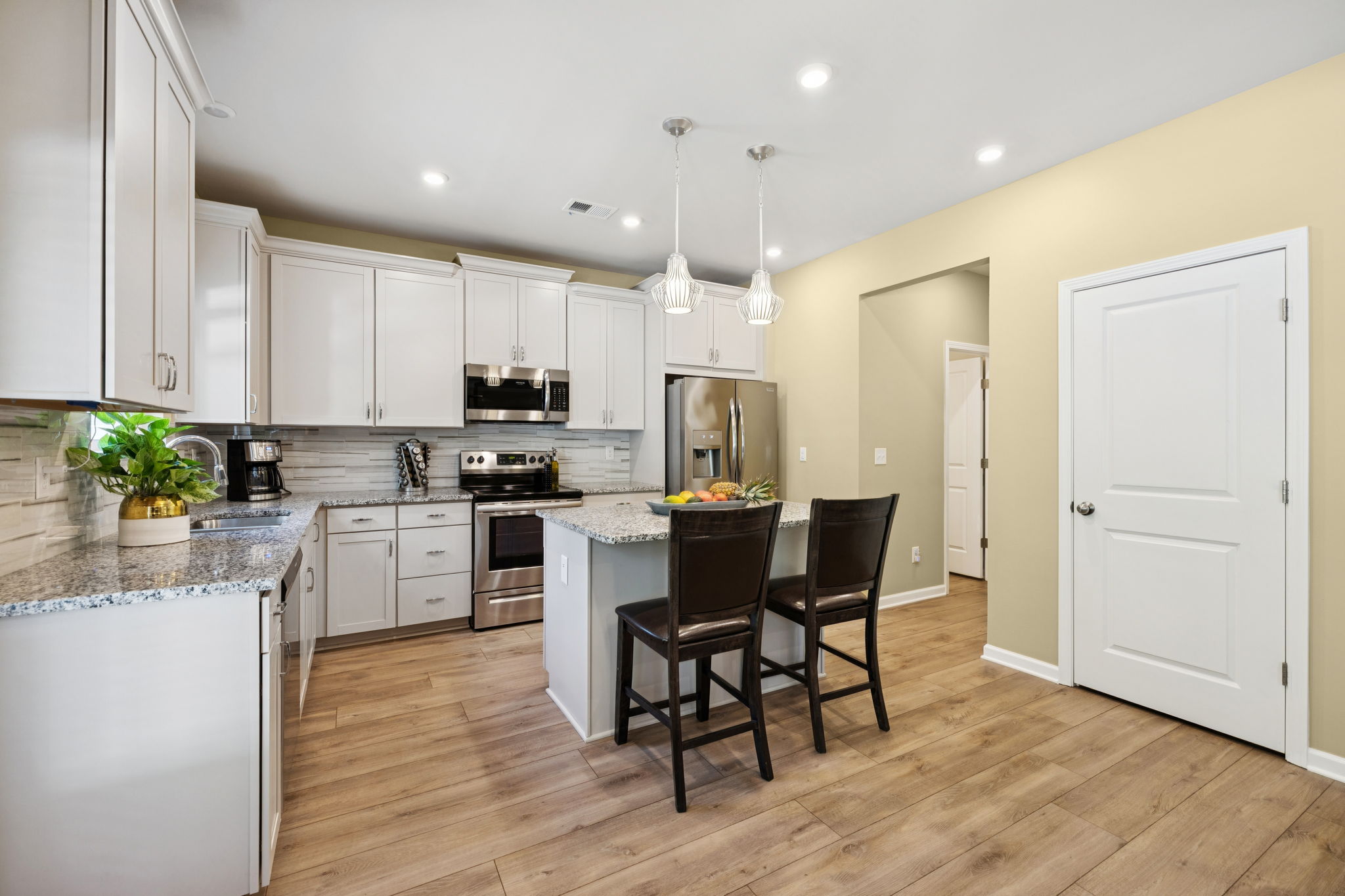 Island Kitchen with granite and brushed nickel hardware package.