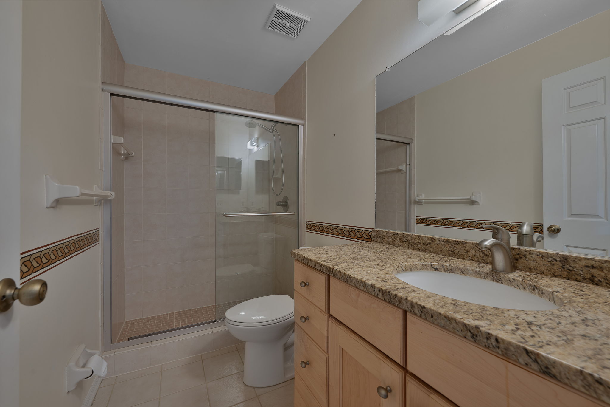 Primary Bath with Wood Cabinets, Granite Countertops, Glass Doors, Tile Floors