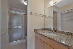Primary Bath with Wood Cabinets, Granite Countertops, Glass Doors, Tile Floors