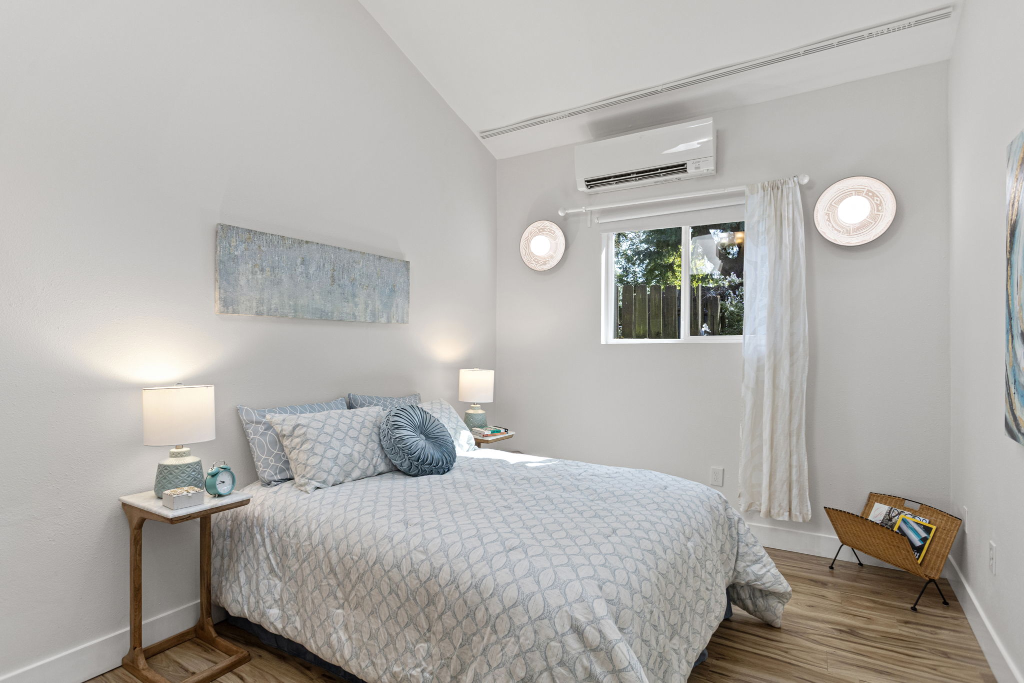 The second bedroom — vaulted ceiling, mini-split, wall sconces, south-facing window. Not what you'd expect at this level.
