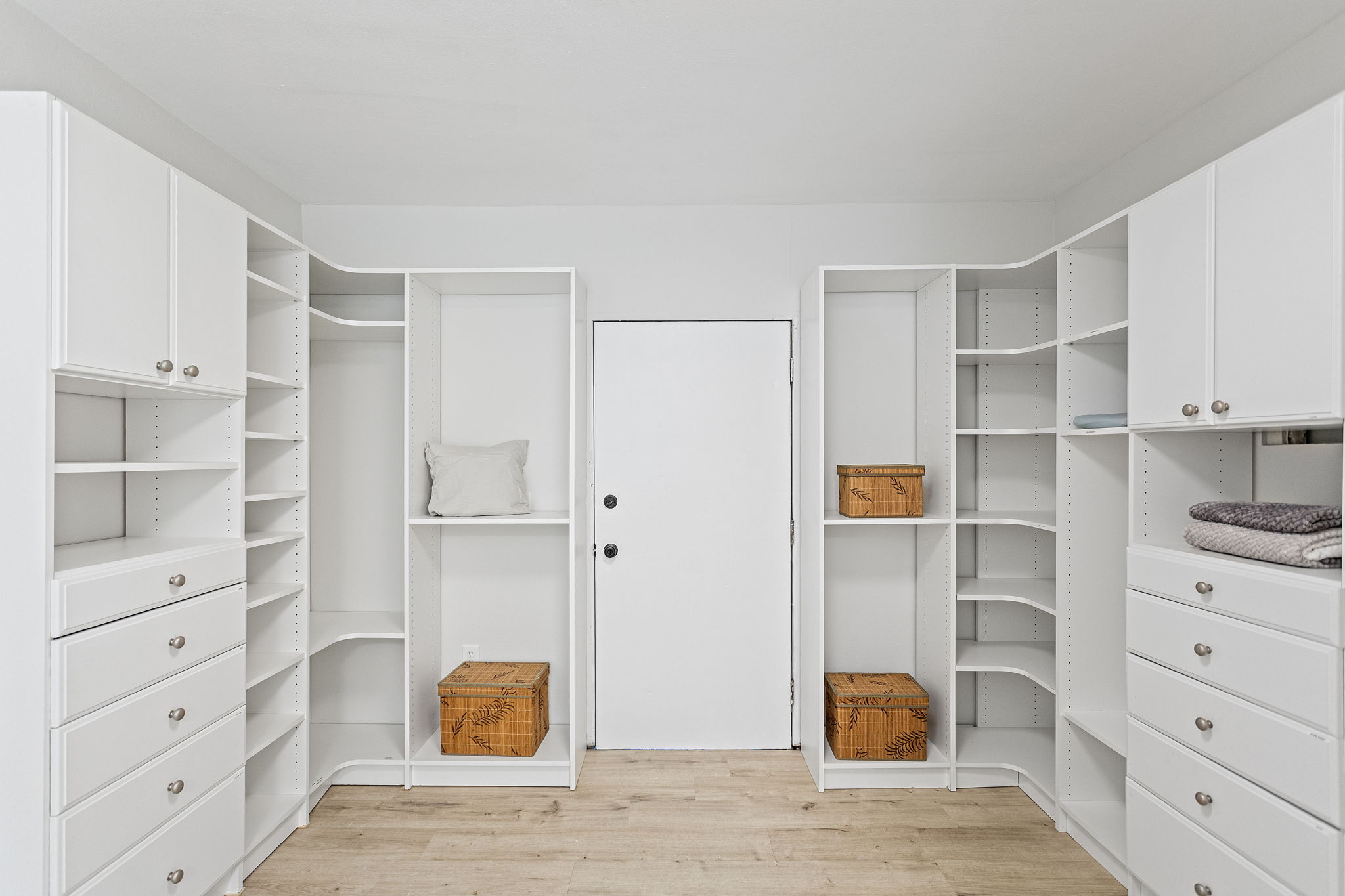 The walk-in delivers: full custom organization system, floor to ceiling, with a deadbolted door to the exterior storage room beyond.