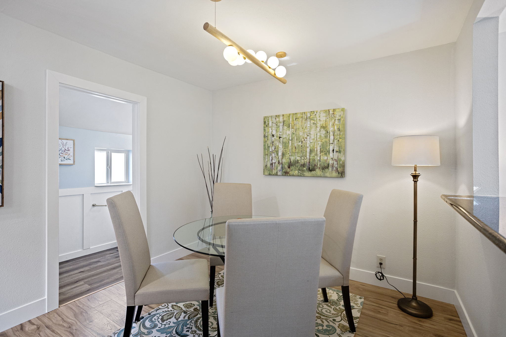 Formal dining room is anchored with branching globe pendant. To the left, the ¾ bath helps keep guest traffic on this floor.
