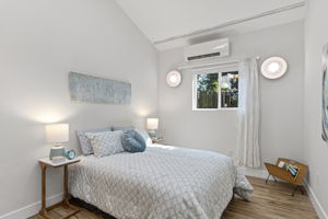 The second bedroom — vaulted ceiling, mini-split, wall sconces, south-facing window. Not what you'd expect at this level.