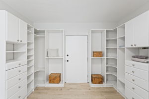 The walk-in delivers: full custom organization system, floor to ceiling, with a deadbolted door to the exterior storage room beyond.