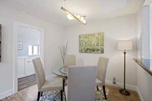 Formal dining room is anchored with branching globe pendant. To the left, the ¾ bath helps keep guest traffic on this floor.