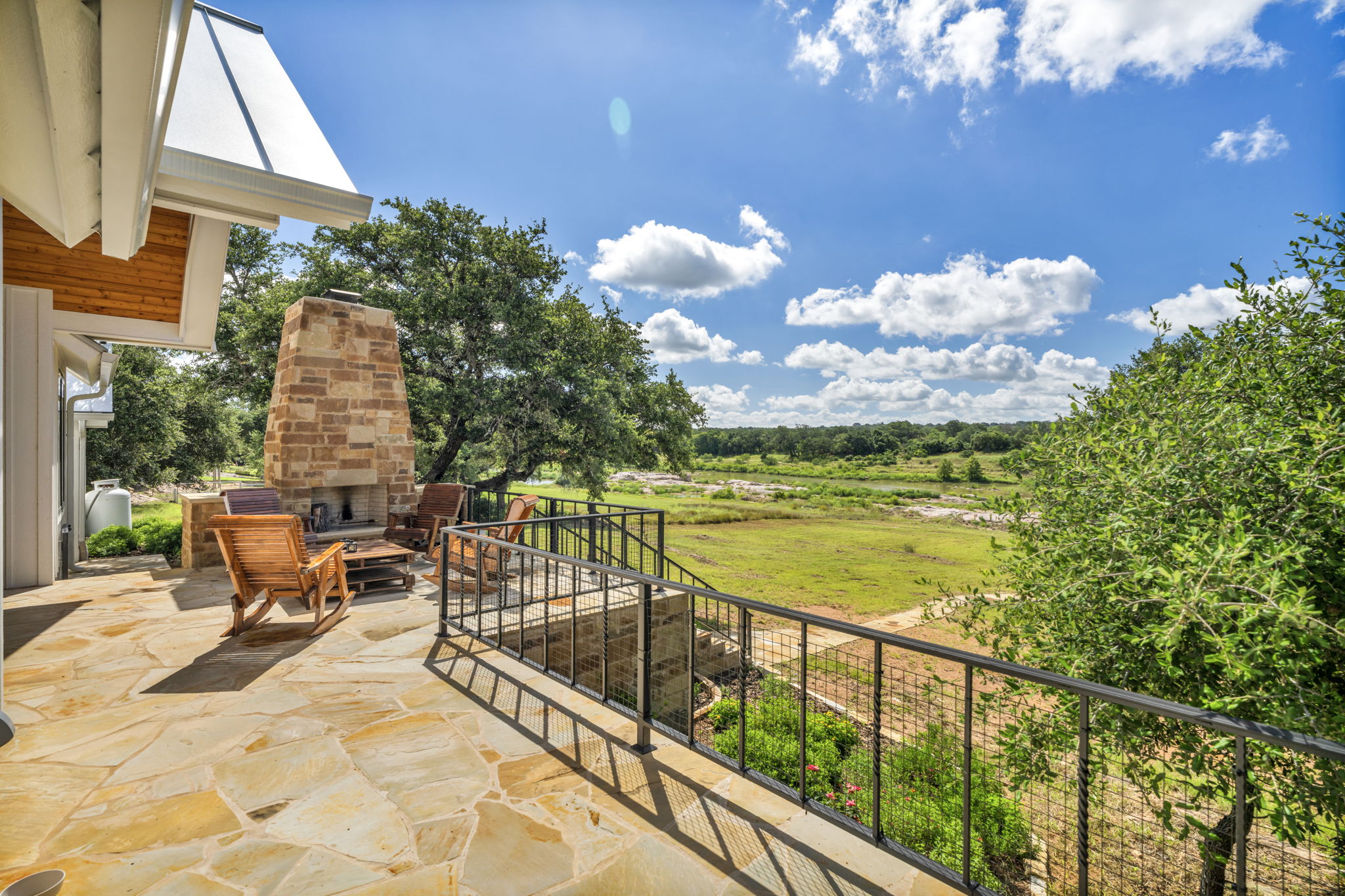 View from patio off main bedroom to outdoor entertaining and dining area with stone fireplace