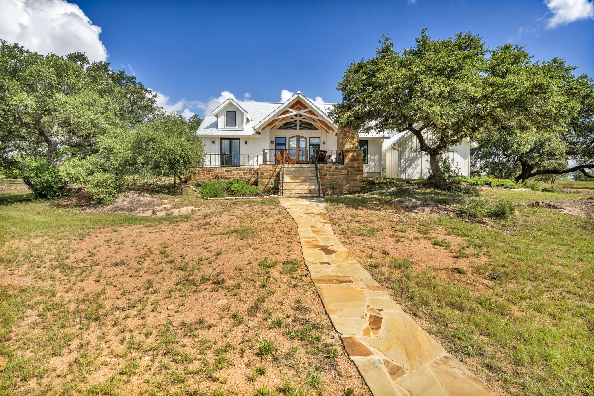 View from the river includes the flagstone walkway to the fire pit sitting area