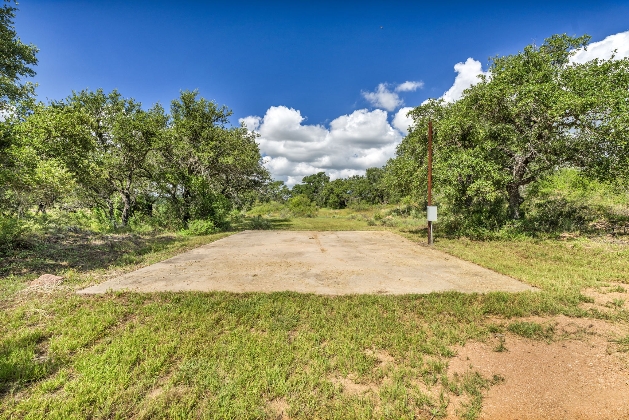 Pad ready for a motor home or pickle ball court or additional picnic area has electric outlet and ready for additional fun or place to camp