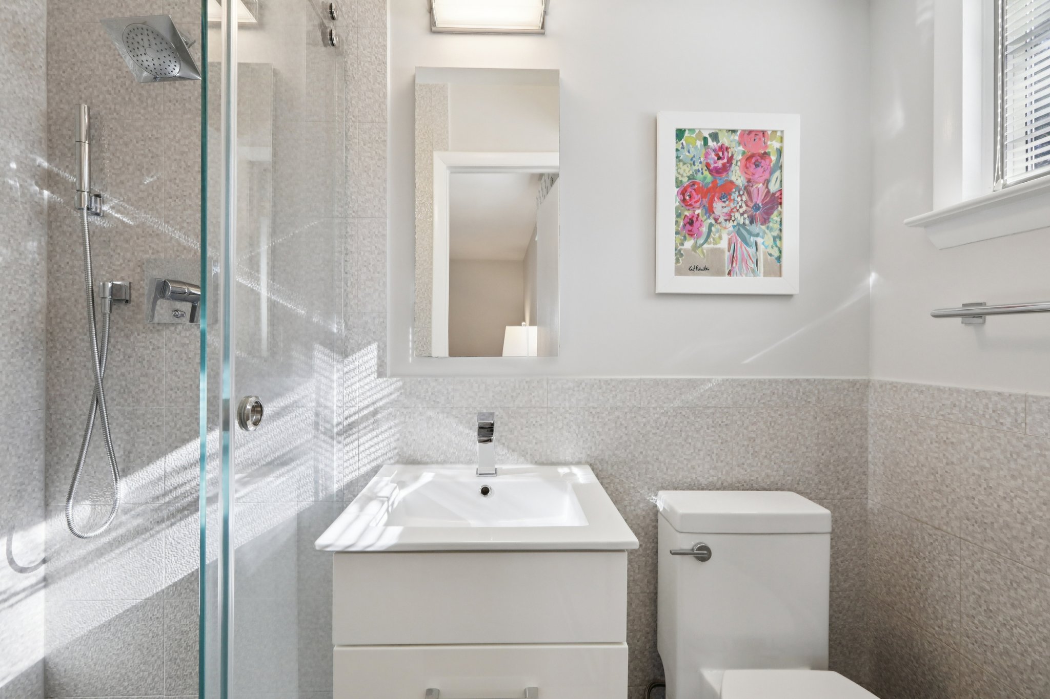 Totally renovated en-suite Primary Bath with window, newly tiled shower, wainscotted-tiled walls, new sink and commode.