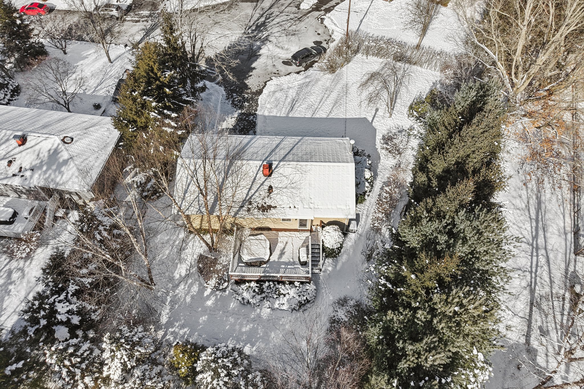 Shows the home tucked away at the end of the cul-de-sac, with flat property and mature, well cared for plantings. Also shows a full view of the deck.