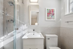 Totally renovated en-suite Primary Bath with window, newly tiled shower, wainscotted-tiled walls, new sink and commode.