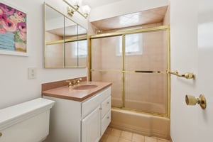 Half bathroom with updated shower door, new cabinet and commode.