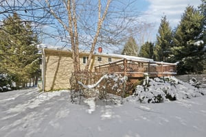 View of rear yard and deck looking toward the front of the path from the right side of the driveway. Notice the mature well care for plantings.