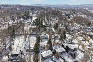 This view shows the home at the mid and lower portion of the picture as well as adjoining properties and a skyline in the distance.