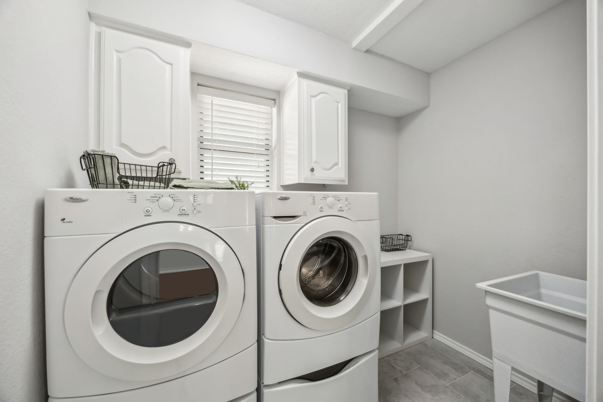 This laundry Room is spacious and includes a sink and storage  as well.  The Washer and Dryer Stay with the home!  Don't miss the New Flooring!