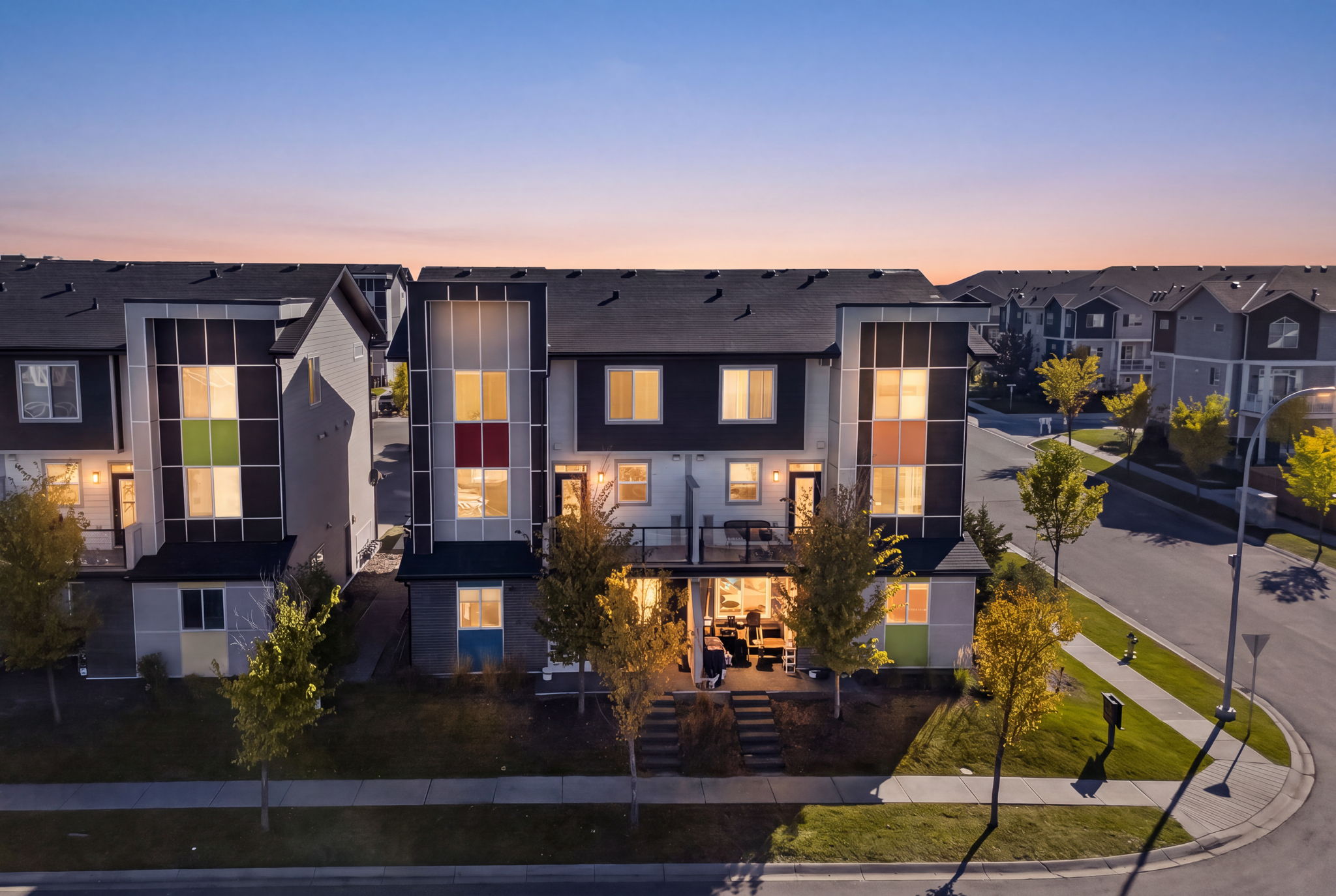 End unit in a modern four-plex, lit up at dusk