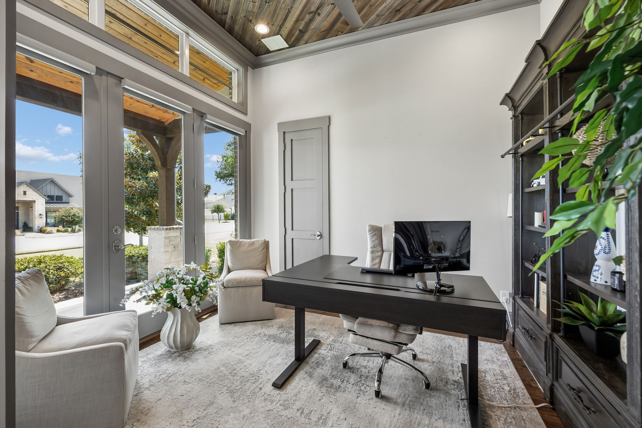 A Private Office with Architectural Character – Positioned just off the entry, the executive office features tall windows, abundant natural light, a wood-paneled ceiling, and barn-door access that provides privacy without closing the room off completely.