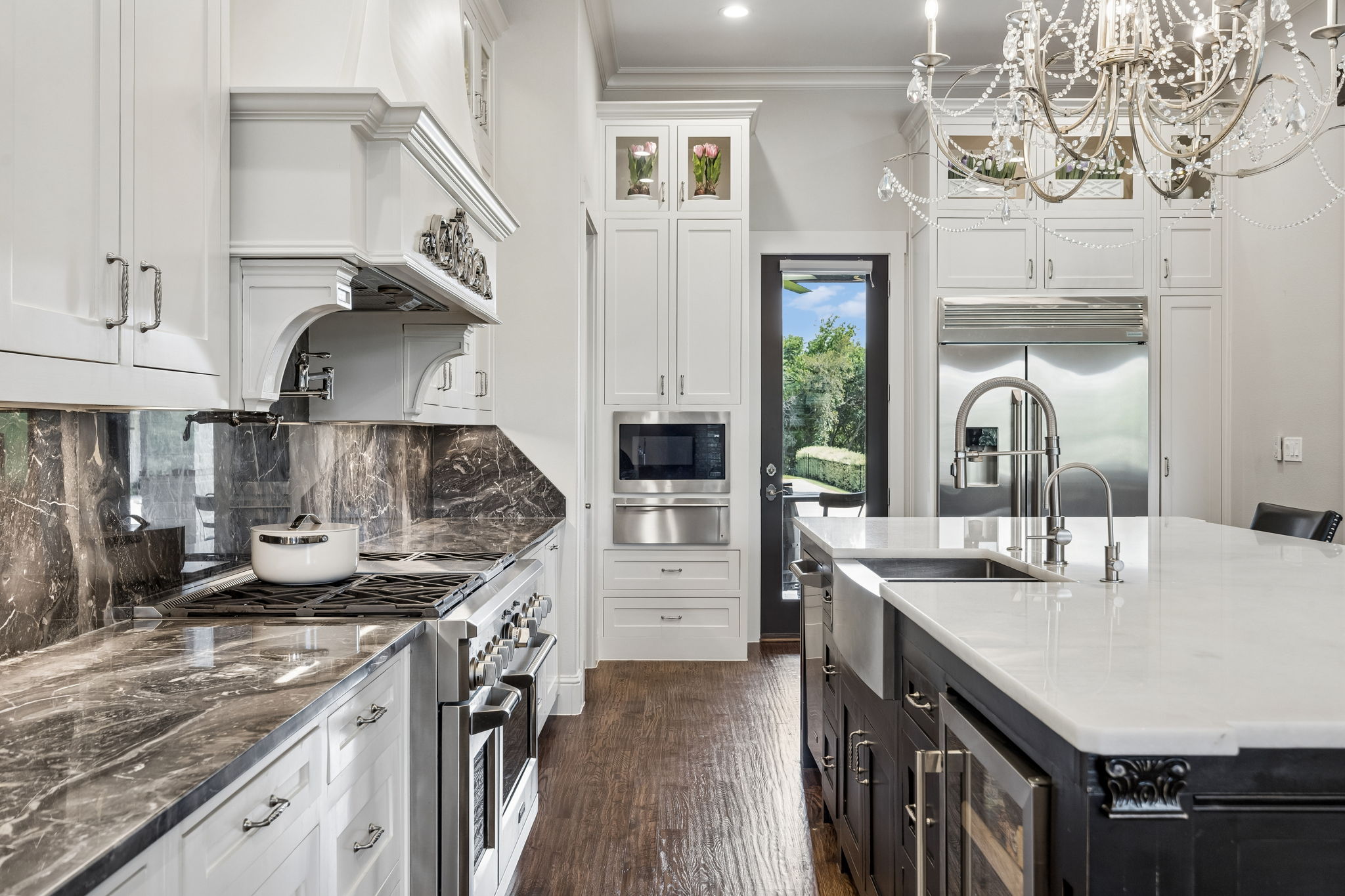 A Professional Kitchen with Purpose – The 48-inch GE Monogram gas range, pot filler, deep farmhouse sink, quartz island, and extensive cabinetry create a highly functional workspace designed for serious cooking and effortless hosting.