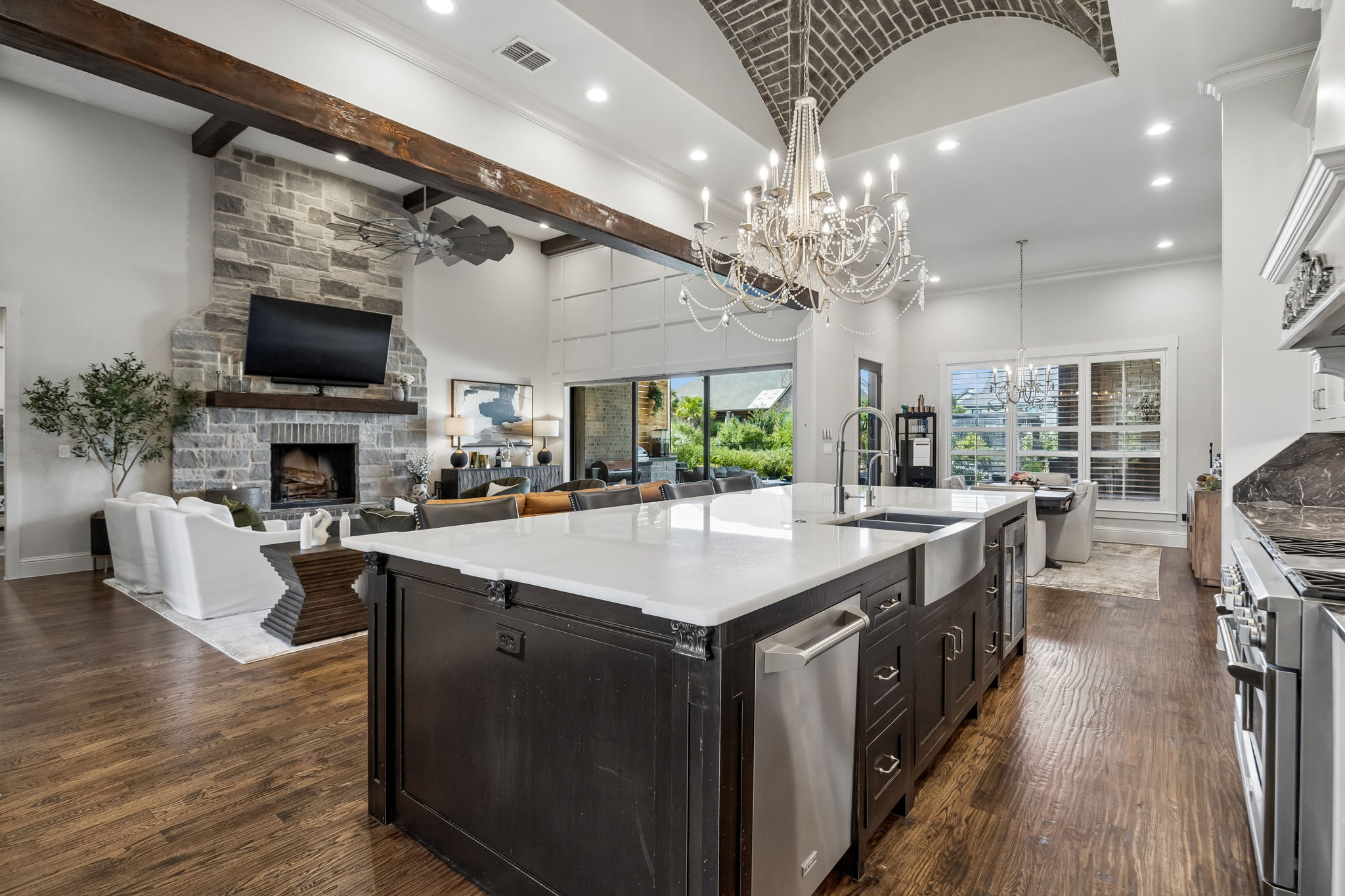 An Island That Works as Hard as It Entertains – Expansive quartz counters provide room for preparation, serving, and seating, while the integrated dishwasher, farmhouse sink, wine cooler, storage, and electrical outlets add convenience.