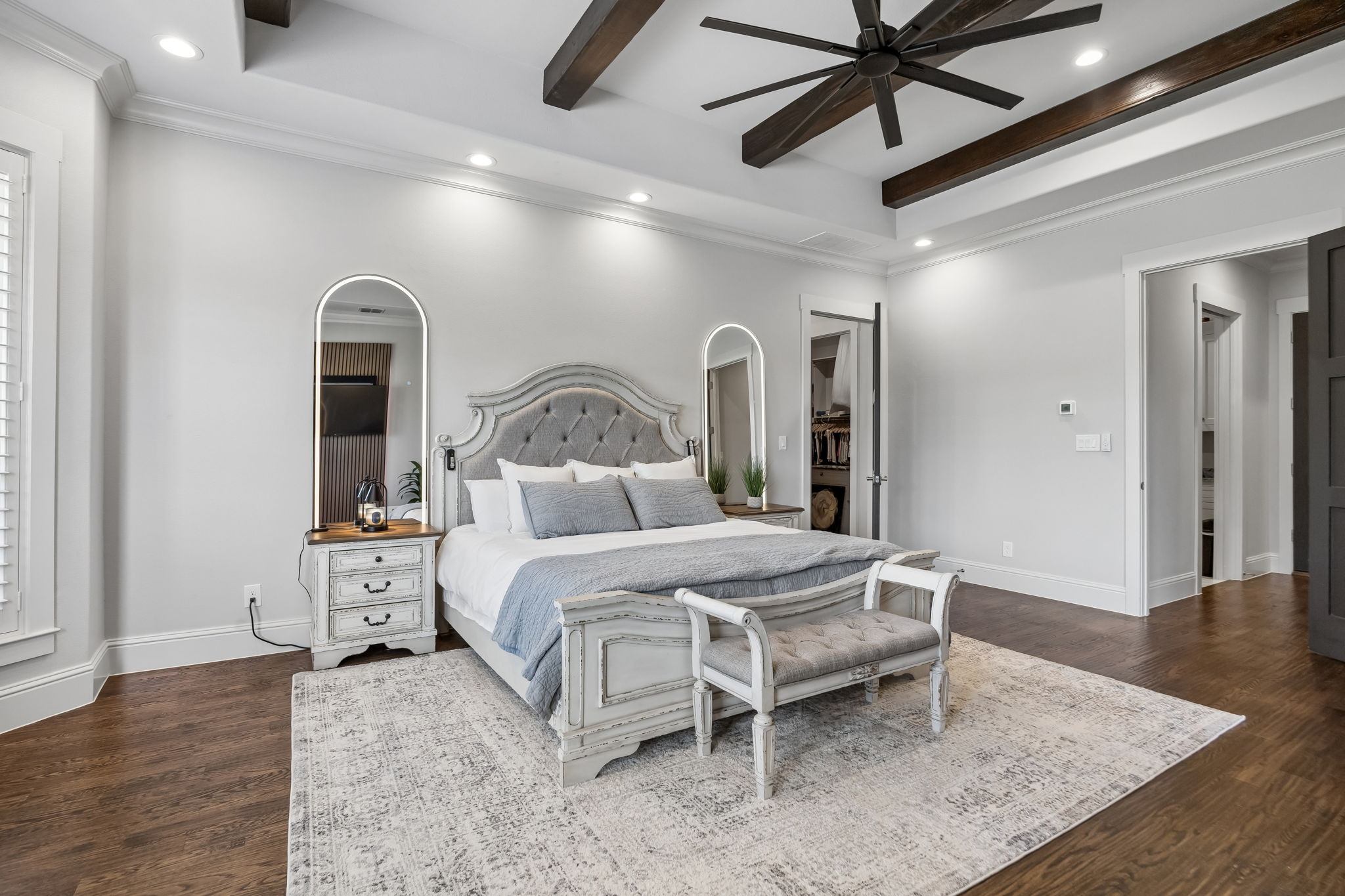 Architectural Detail Above – Dark exposed beams, recessed lighting, and a large ceiling fan add depth and character to the tray ceiling while emphasizing the scale of the primary bedroom.
