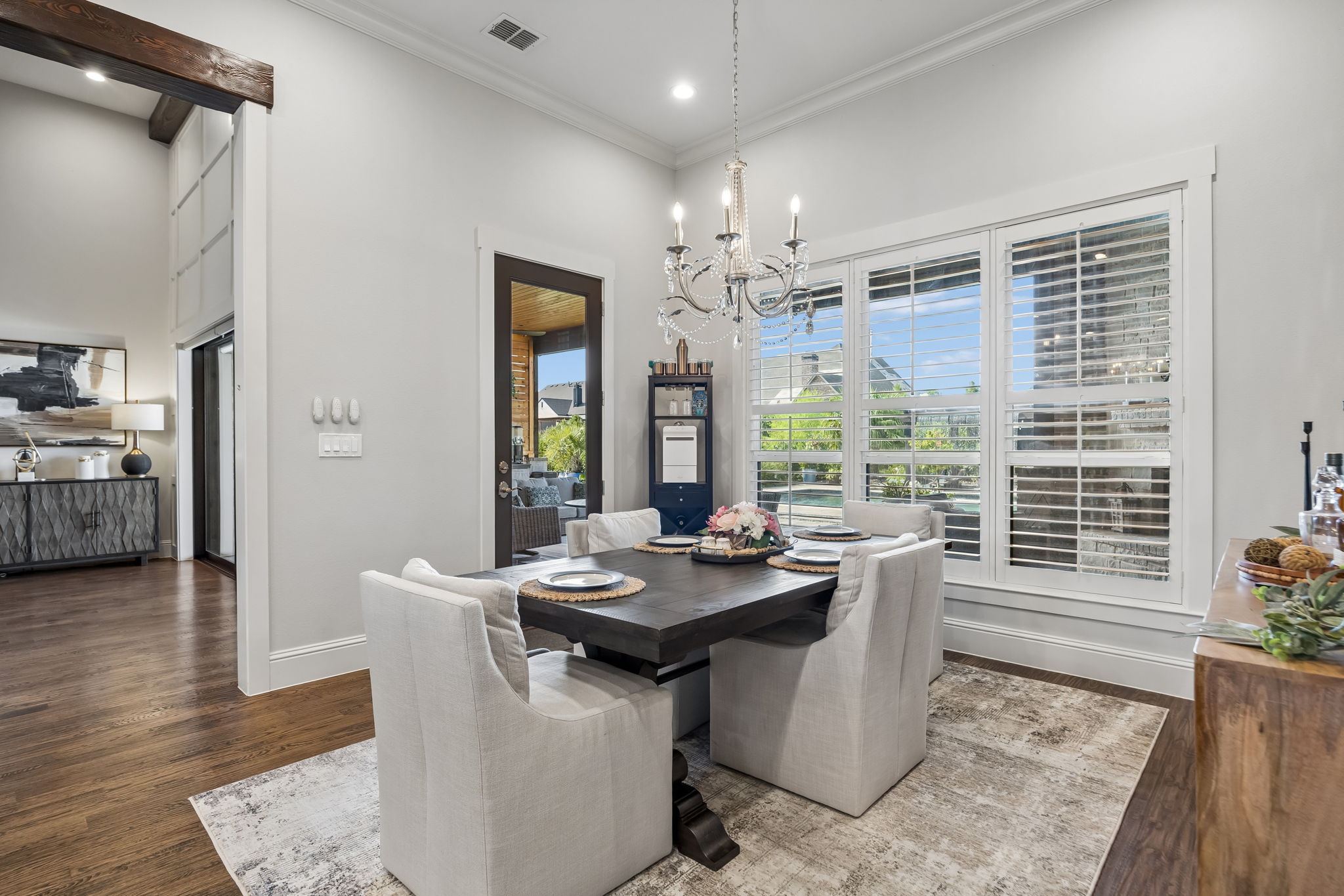 Dining with Direct Terrace Access – The breakfast area sits beside a glass exterior door and a wall of windows, making it easy to move between indoor meals and outdoor entertaining.