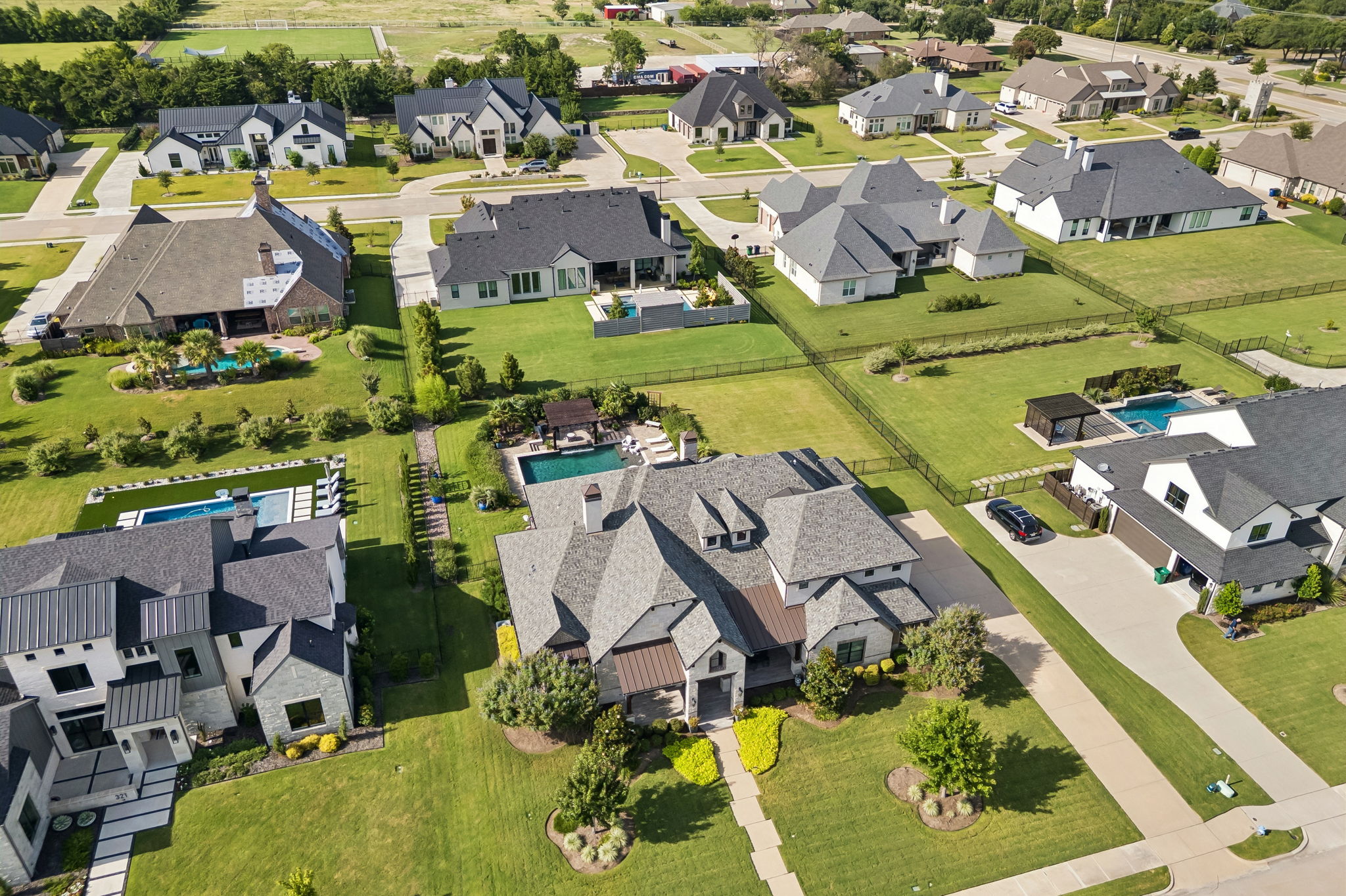 A Custom Home in an Established Heath Setting – The aerial perspective highlights the home’s architectural scale, landscaped grounds, side-entry drive, and position within The Renaissance.