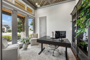 A Private Office with Architectural Character – Positioned just off the entry, the executive office features tall windows, abundant natural light, a wood-paneled ceiling, and barn-door access that provides privacy without closing the room off completely.