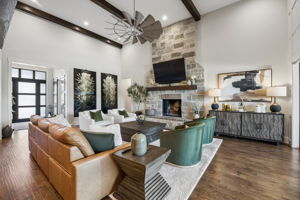 Warm Materials, Impressive Scale – Hand-scraped hardwood floors, a full-height stone fireplace, and dark ceiling beams add warmth and texture to the soaring great room, creating an inviting setting for both everyday living and larger gatherings.