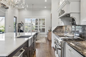 Designed for Efficient Meal Preparation – The generous work aisle places the professional range, sink, island storage, and nearby dining area within easy reach, making the kitchen practical for both everyday meals and larger events.