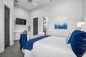 This secondary bedroom includes a built-in desk, private bath access, generous closet storage, and enough space to serve comfortably as both a sleeping area and personal retreat.