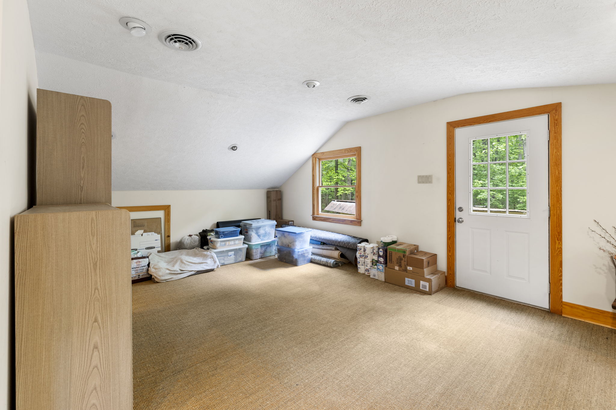 Sisel rug/carpeting in finished 2nd floor of garage with a direct exterior entrance, closet space, & potential space for a full bathroom.