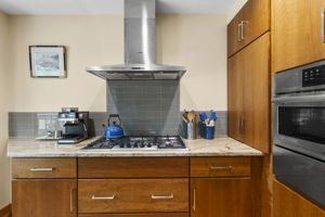 Propane gas cooktop with stainless steel range hood.