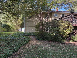 Fall view of the same picture without snow, showing mature trees and level yard.