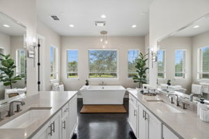 Primary bathroom with separate vanities.