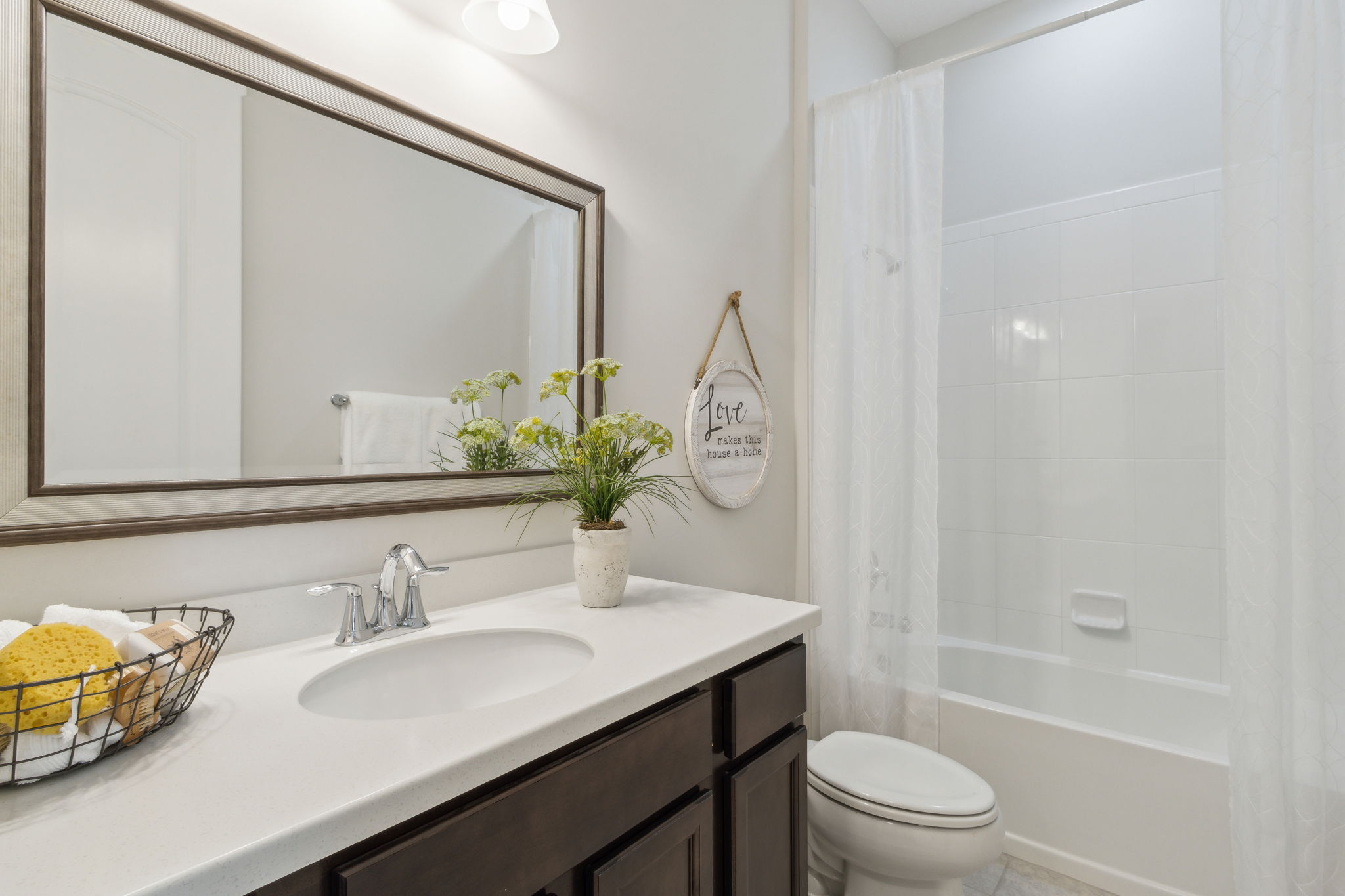 The guest bath has shower/tub combo and upgraded vanity, mirror and lighting.