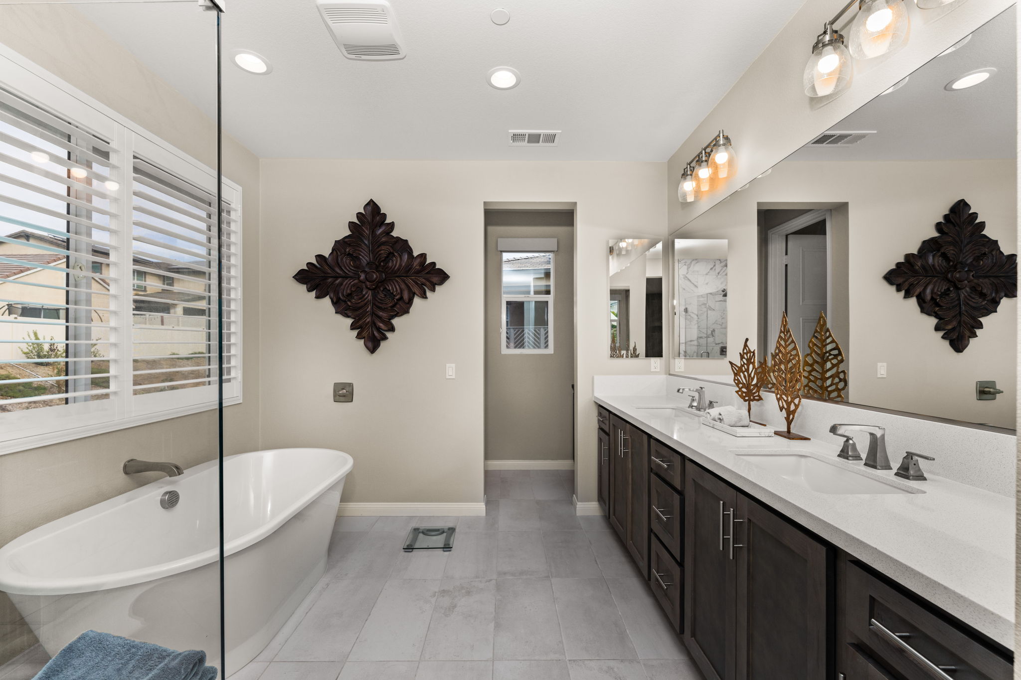 Highly upgraded primary suite bathroom featuring upgraded tile, a deep soaking tub, and a large tile shower