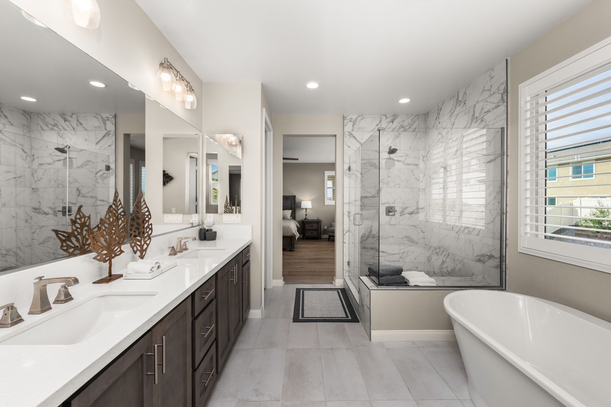 Highly upgraded primary suite bathroom featuring upgraded tile, a deep soaking tub, and a large tile shower