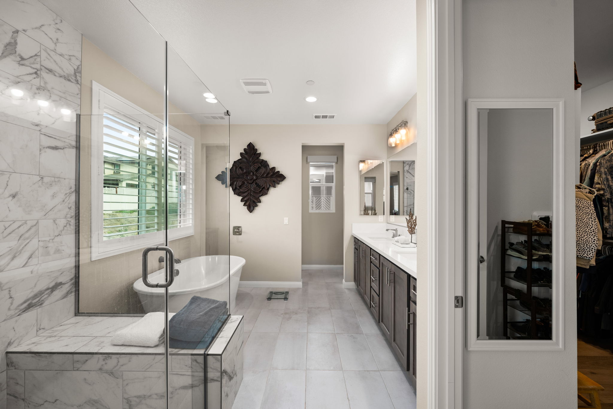 Highly upgraded primary suite bathroom featuring upgraded tile, a deep soaking tub, and a large tile shower