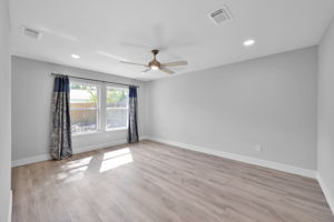 The PRIMARY BEDROOM sits at the end of the hallway (View upon entry). Looks out to the backyard.