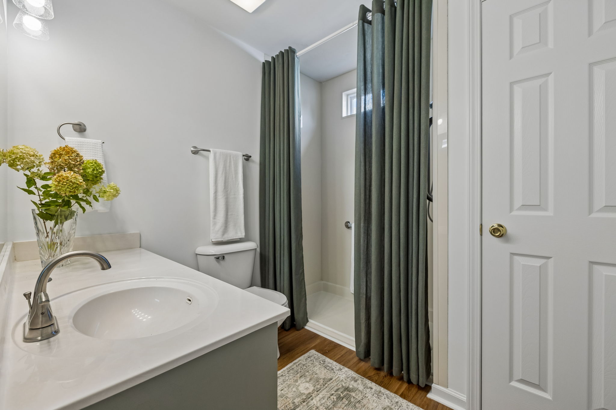 Main floor guest bath with linen closet, ADA walk in shower with hand held, spacious vanity and tons of storage, New brushed nickel fixtures.