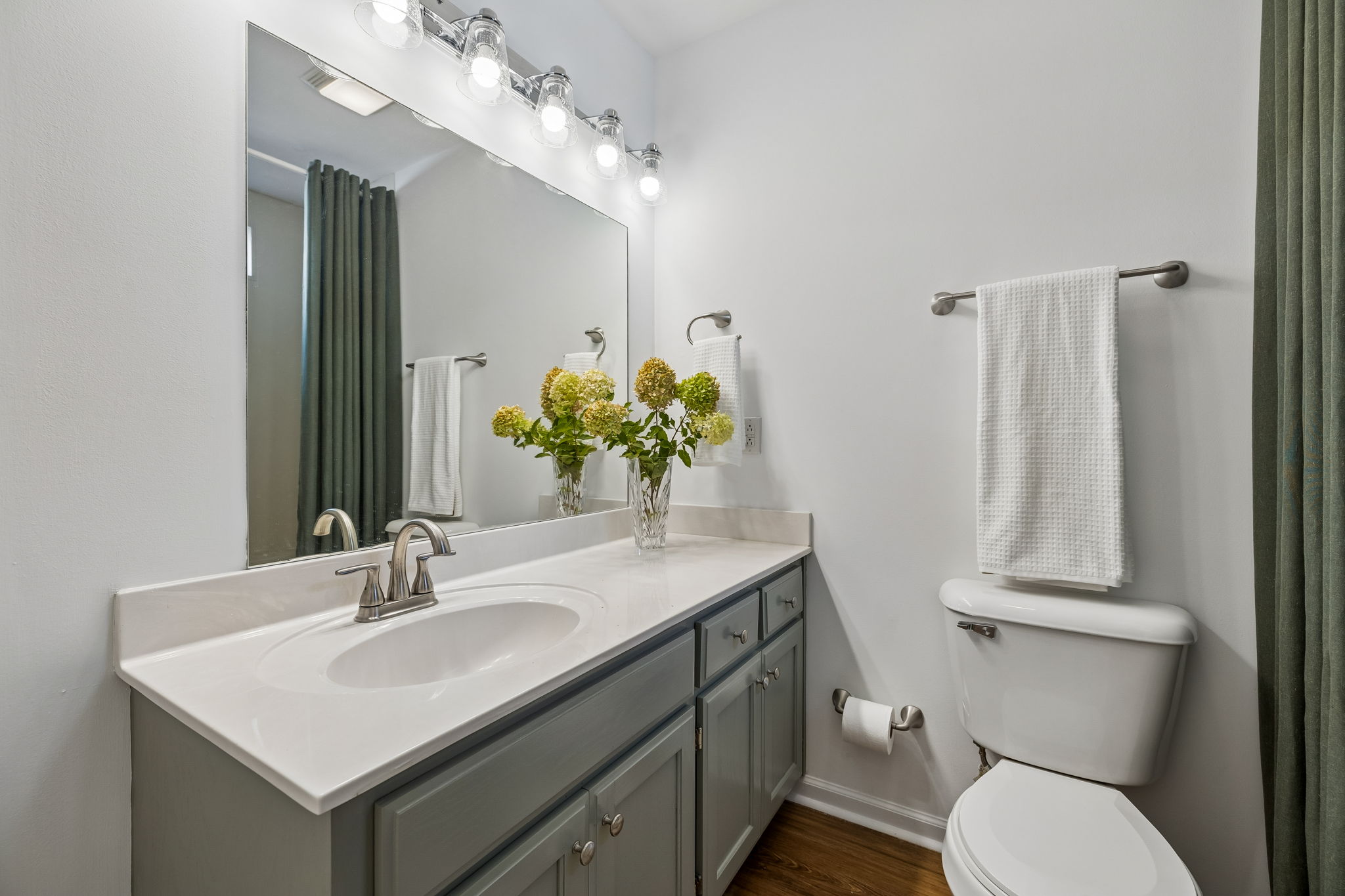 Main floor guest bath with painted oak cabinets.