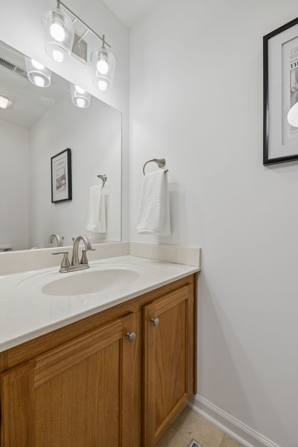 Upstairs bonus half bath with solid oak cabinets and new brushed nickel fixtures.