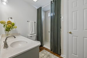 Main floor guest bath with linen closet, ADA walk in shower with hand held, spacious vanity and tons of storage, New brushed nickel fixtures.