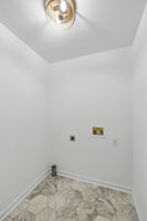Laundry area with room for cleaning supplies. New  flooring, new paint, new fixtures.