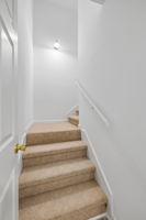 Stairs leading to over the garage bonus room with separate HVAC, half bath Berber carpet, and tons of space with a door for privacy!